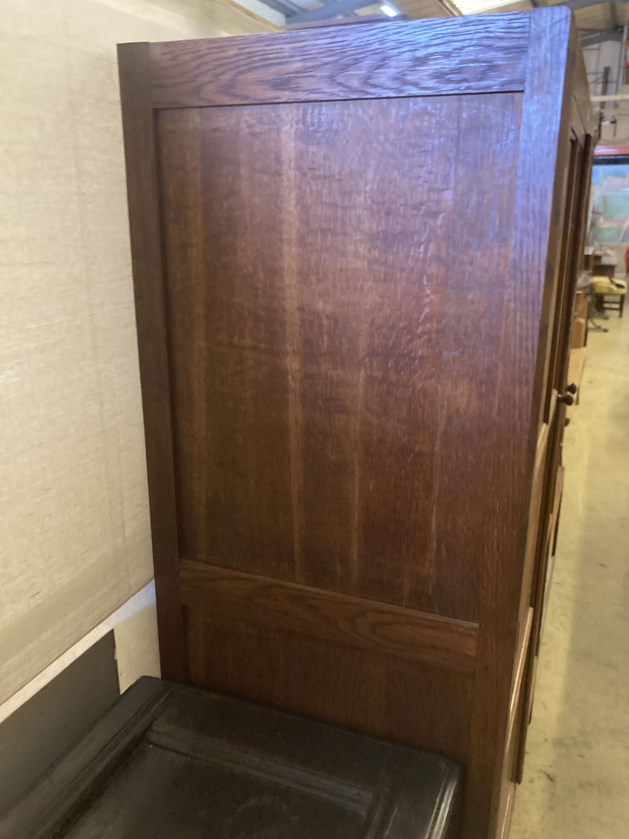 An Arts & Crafts style panelled oak two door wardrobe, width 105cm, depth 55cm, height 168cm